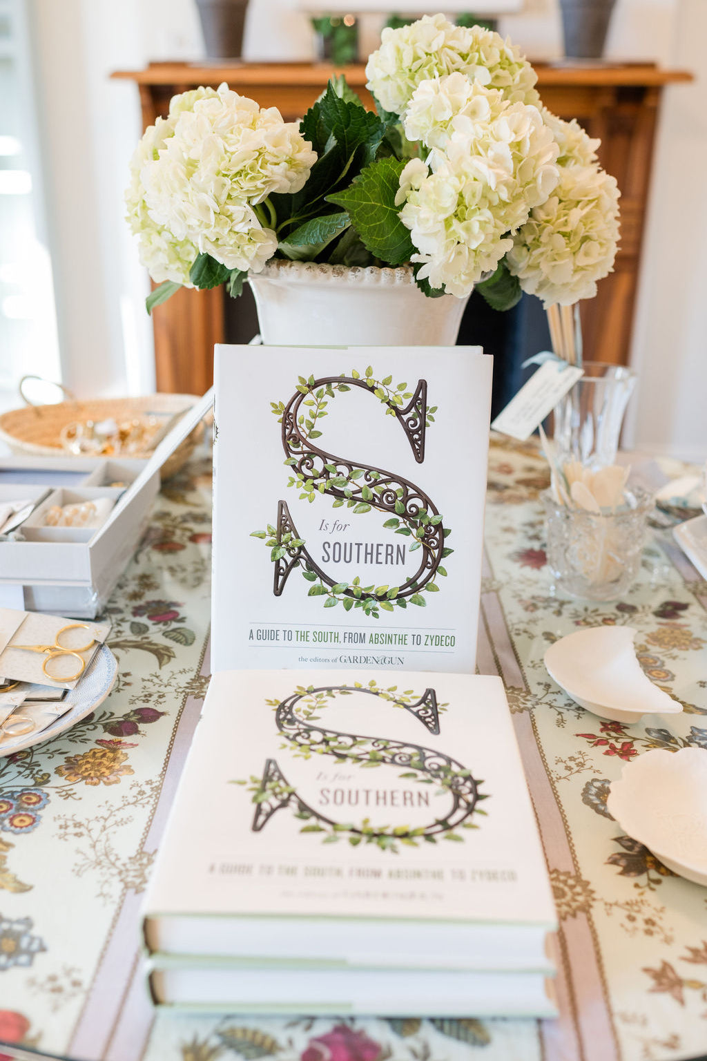 Book titled 'S is for Southern' on a table with floral arrangement