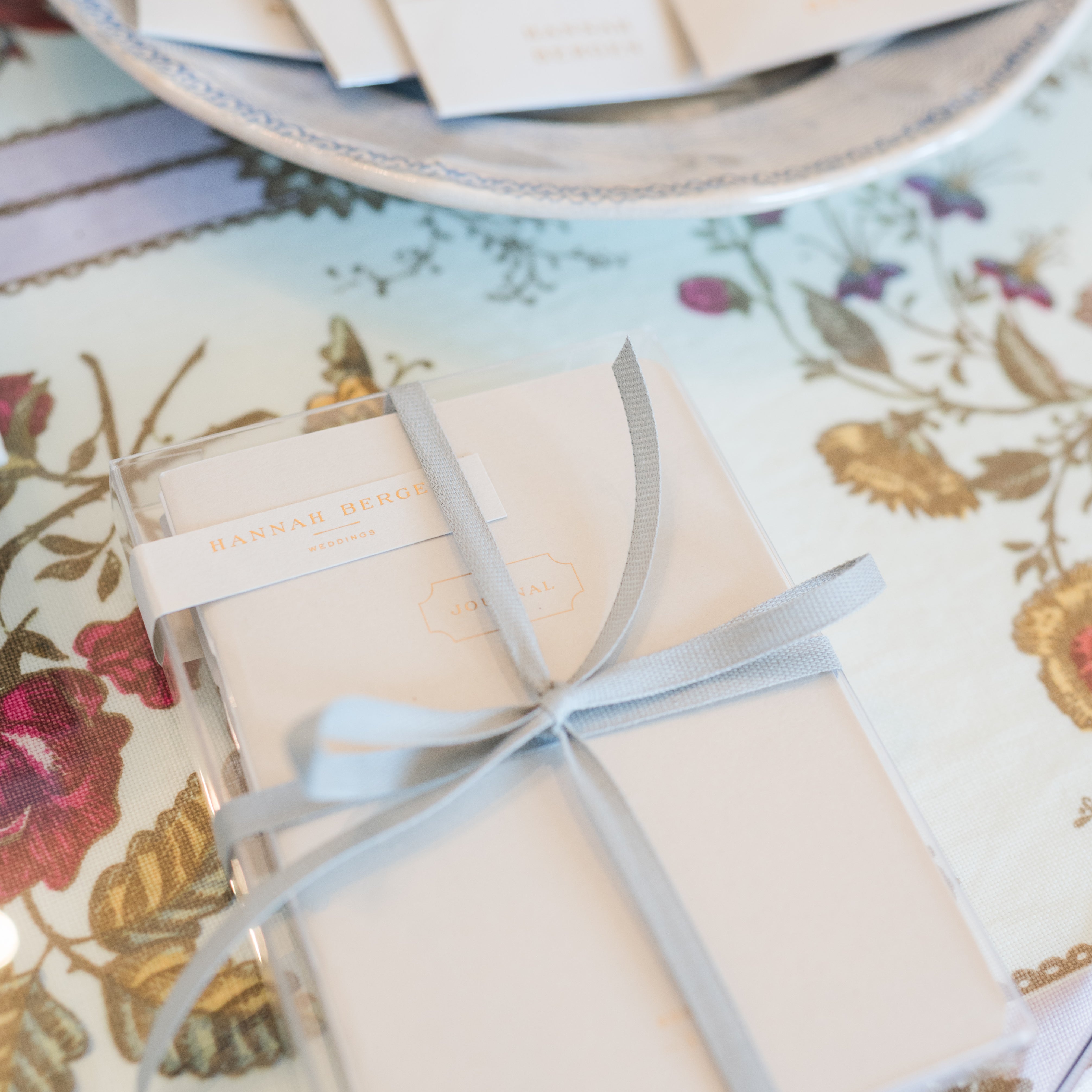 Gift box with a ribbon on a floral tablecloth