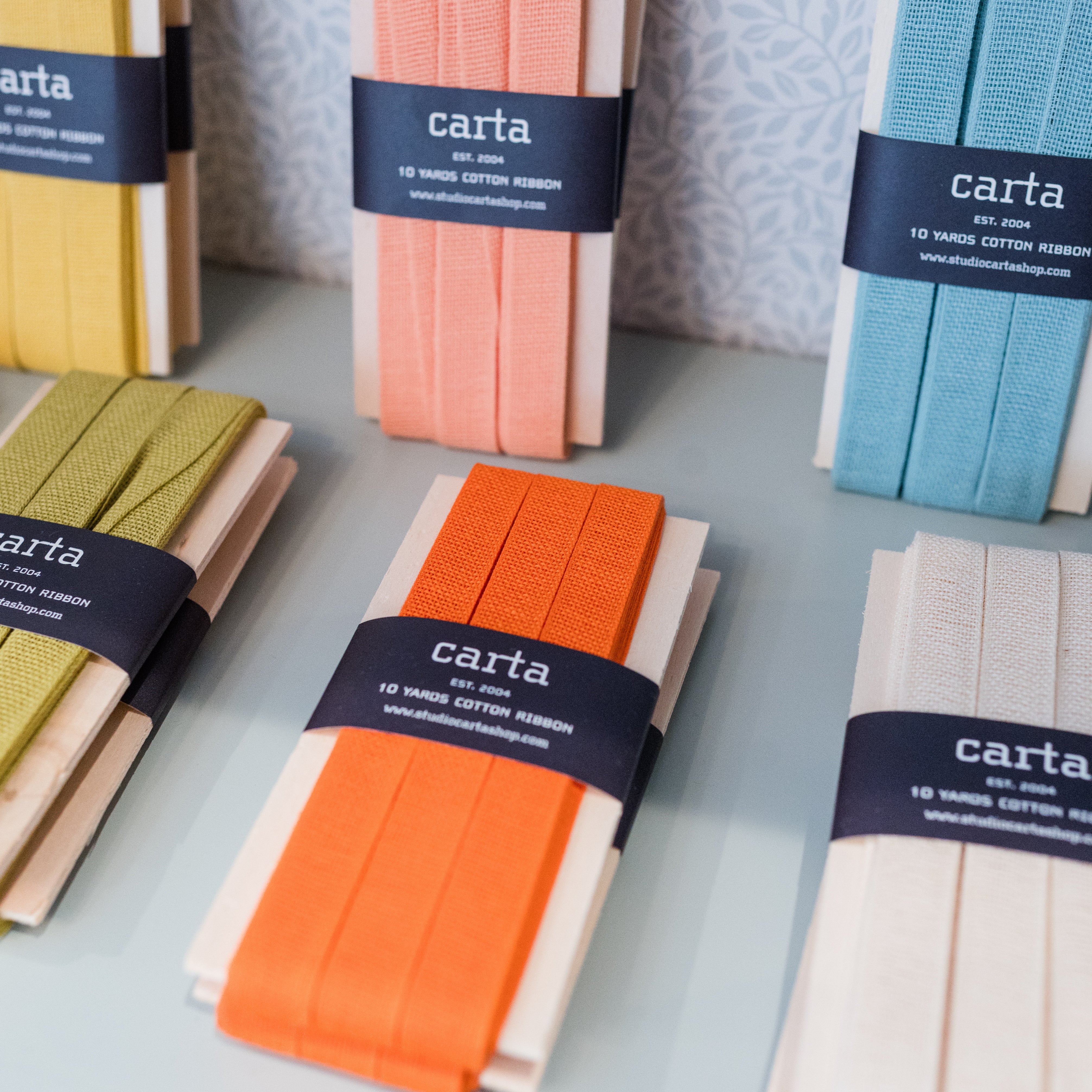 Packaged cotton strips with 'carta' branding on a light surface.